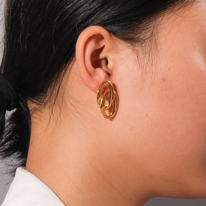 Chic 18K gold geometric double oval interlaced earrings worn on a female ear model