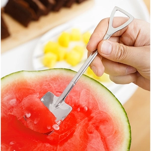 Creative spade-shaped stainless steel spoon scooping fresh watermelon flesh for dessert
