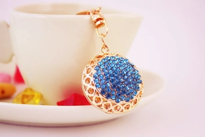 Detailed view of a golden alloy key ring with sparkling blue crystal rhinestones