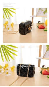 Detail of glossy black patent leather mini bag with classic quilted pattern and gold chain