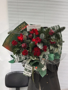 Detail of Christmas bouquet with red roses and elk pattern gold-stamped wrapping paper