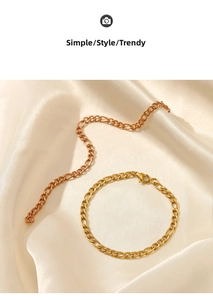 Close-up of gold Cuban link chain set arranged on elegant silk fabric background