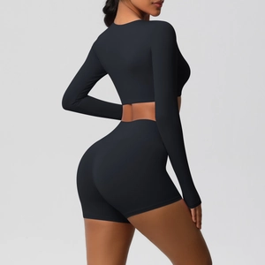 Detail view of black long sleeve crop top and high waist shorts gym set on model