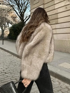 Back view of a soft brown faux fur coat paired with black jeans on a European street