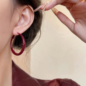 Minimalist glossy wine red hoop earrings shown on a model with a stylish natural look