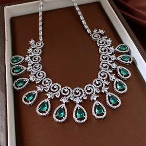 Macro view of silver necklace with green waterdrop gems and zircons in a jewelry box