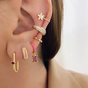 Detail shot of gold-plated earrings with red resin and zircon stones on model