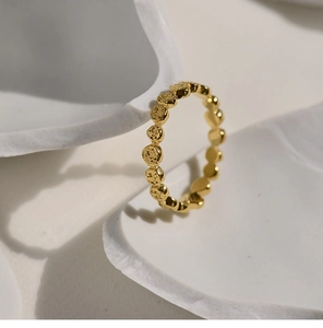 Detail of gold-plated titanium steel honeycomb ring with textured hammered finish