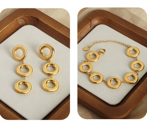 Detailed close-up of 18k gold-plated geometric circle earrings and bracelet set on display