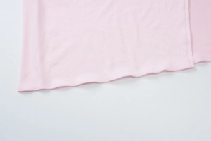Detailed view of pink fabric with high-quality wavy overlock stitching and neat seams