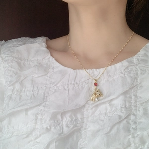 Detail of bear pendant with rhinestones, red heart, and pearl on gold chain