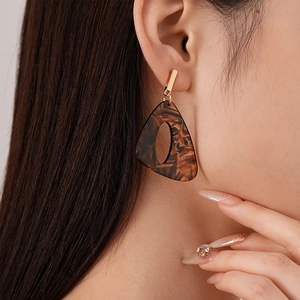 Vintage tortoiseshell resin geometric earrings with gold accents on model profile