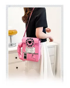Macro view of pink retro phone-shaped crossbody bag with Hotline and dial details