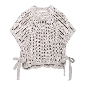 Detail of chunky knit vest featuring hollow-out texture and side bow-tie accents
