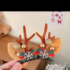 Detail of Christmas reindeer antler hair clips with red plaid bows and gold balls