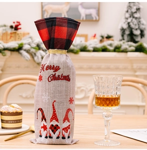 Close-up of Merry Christmas gnome wine bottle bag with plaid trim on a wooden table