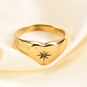Detailed view of 18K gold plated heart signet ring with an engraved star and zircon