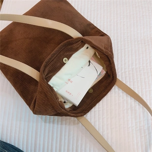 Detail view of corduroy tote bag featuring magnetic closure and spacious fabric lining