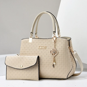 Detail of beige woven texture tote set with gold hardware and removable strap