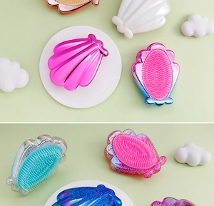 Detailed view of various glitter and electroplated shell-shaped detangling hair combs
