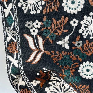 Macro detail of intricate floral embroidery on soft cashmere-feel winter scarf fabric