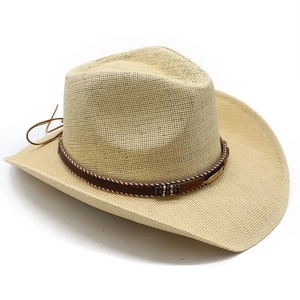 Detail of straw cowboy hat with wide brim, brown braided band and feather pendant charm