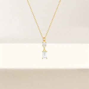 Macro view of gold S925 silver necklace featuring emerald-cut and round CZ stones