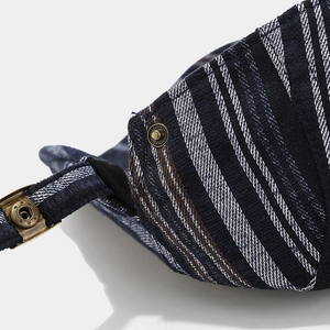 Macro detail of navy plaid fabric and vintage bronze metal buckle on newsboy cap