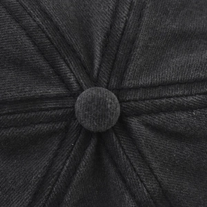 Macro shot of the top button and radial stitching on a washed black distressed baseball cap
