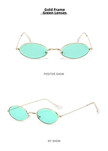 Close-up of retro oval sunglasses with gold metal frame and green tinted lenses
