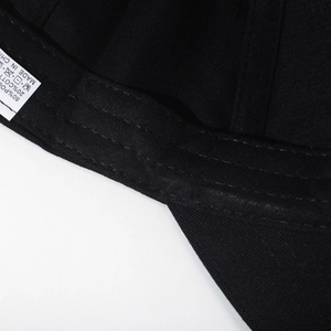 Internal detail of black baseball cap showing washing label and durable stitching
