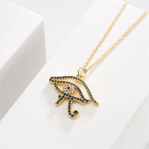 Close-up of golden Horus eye necklace pendant with blue, green, and clear cubic zirconia