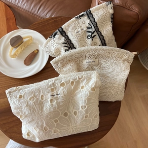 Detail view of lace embroidery patterns and fabric texture on simple wish pouches