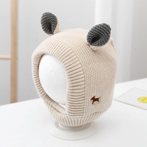 Detail of beige knit baby winter hat with grey animal ears and brown dog embroidery