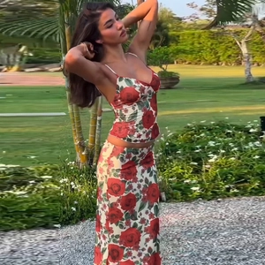 Outdoor view of a floral two-piece set with a red rose printed crop top and long skirt