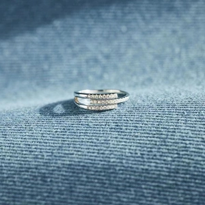 Elegant triple-layer silver ring with sparkling micro-pave cubic zirconia on blue fabric