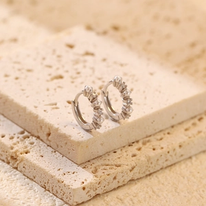 Macro view of silver hoop earrings with set pearls and sparkling cubic zirconia stones