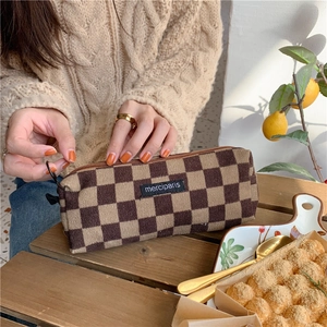 Detailed view of corduroy checkered pencil case with zipper and merciparis logo patch