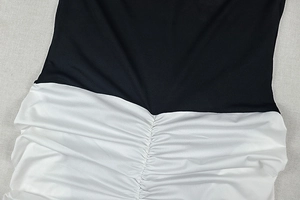 Détail macro de la robe contrastée noir et blanc montrant les fronces et les coutures