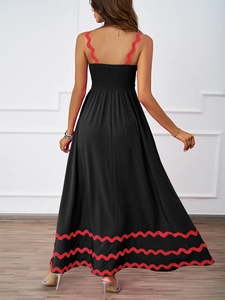 Detail of summer dress featuring scalloped red trim on black back with elastic shirring