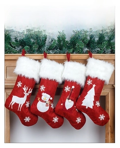 Red burlap Christmas stockings with white faux fur cuffs and embroidered holiday patterns