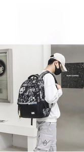Detail view of large capacity black backpack with white art graffiti on side mesh pocket