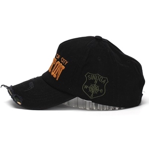 Gros plan d'une casquette de baseball noire usée avec broderie orange et écusson