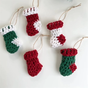 Five handmade mini knitted Christmas stocking ornaments in festive red and green yarn