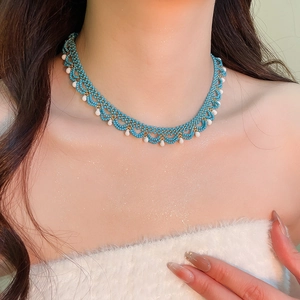 Detailed close-up of sky blue and white beaded lace choker necklace on a female model