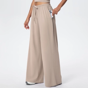 Detail of wide elastic drawstring waistband and side pocket on khaki wide leg pants