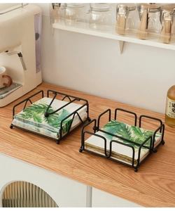 Detail of matte black iron napkin holders with wooden base on a cozy cafe counter