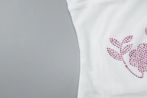 Detail of pink rhinestone flower pattern and white knit fabric on slim fit set