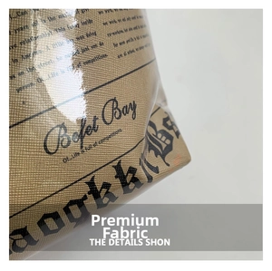 Close-up of vintage newspaper print on brown textured leather of a fashion bucket bag