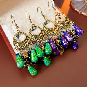 Detail view of vintage bohemian earrings with green and purple teardrop cracked beads